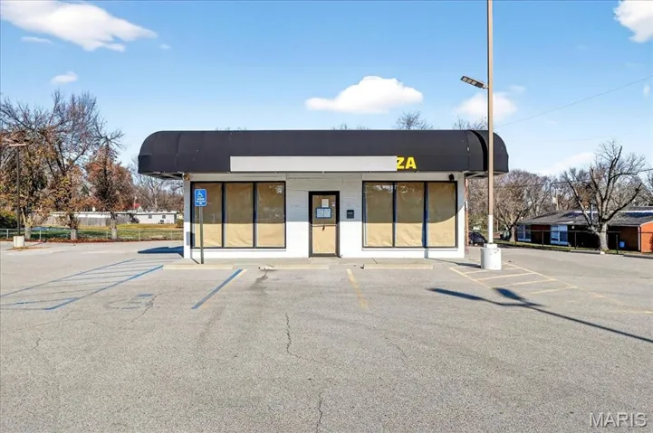 View of commercial property featuring uncovered parking
