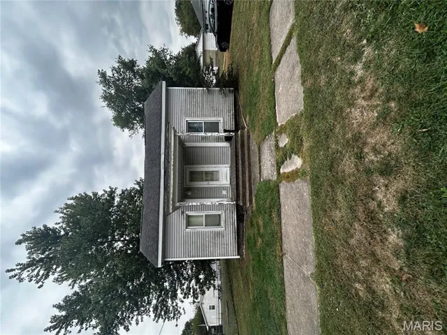 Bungalow-style home with a front lawn, a shingled roof, and covered porch