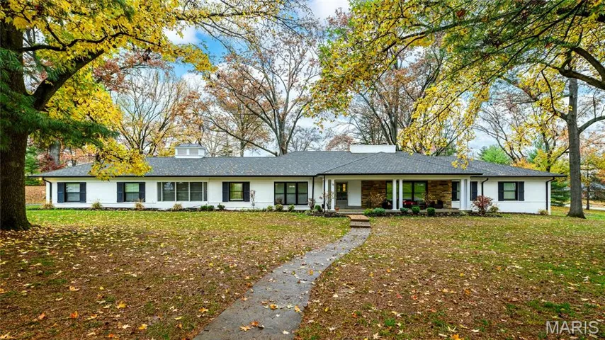 Ranch-style house featuring covered porch, a chimney, and a front lawn