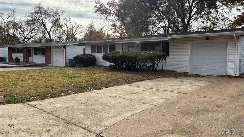 Ranch-style house featuring a garage, driveway, and a front lawn