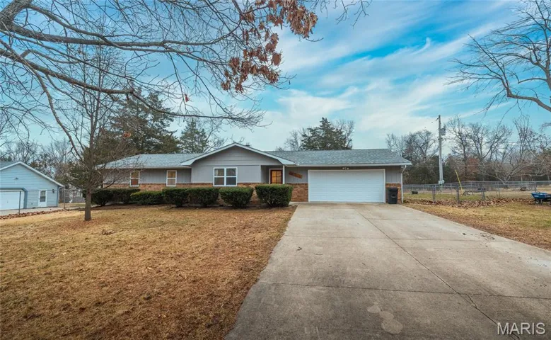 Ranch-style home with driveway, an attached garage, brick siding, and a shingled roof