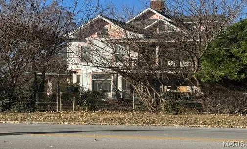 View of front of home featuring a fenced front yard and a chimney