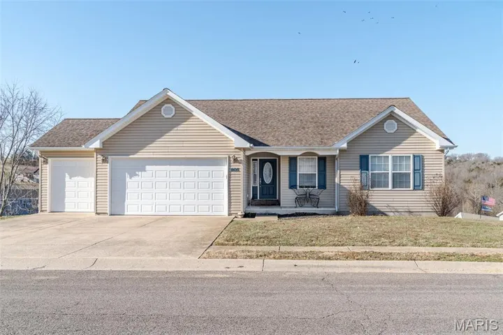 Ranch-style house with covered porch, a garage, driveway, roof with shingles, and a front lawn