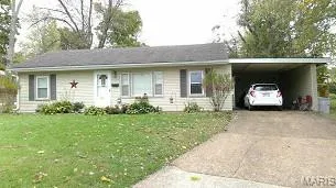 Single story home featuring driveway, an attached carport, and a front lawn