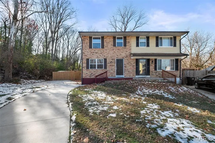 View of front of home featuring brick siding and driveway