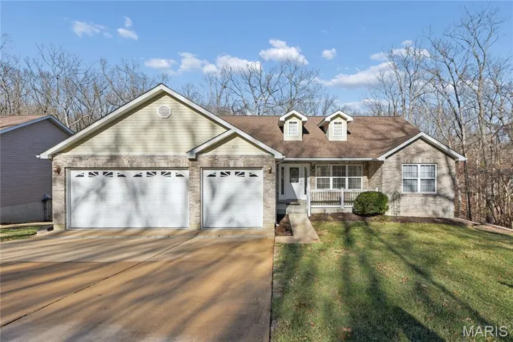 View of front of property featuring brick siding, covered porch, a front yard, concrete driveway, and an attached garage