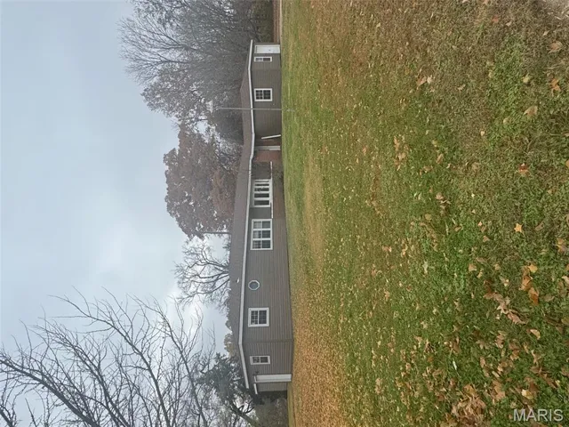 Back of property with a lawn