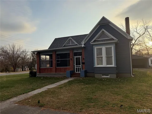 Bungalow featuring a front lawn, a shingled roof, and entry steps