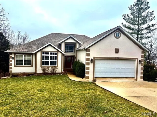 Ranch-style home featuring a front yard, concrete driveway, a garage, stucco siding, and a shingled roof