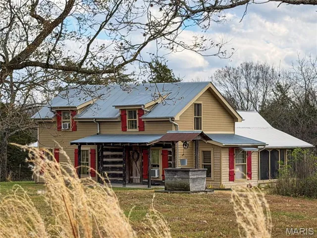 View of front of home with covered porch and a front lawn