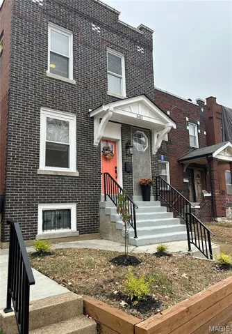 View of front of home featuring new hand railings, and brick siding