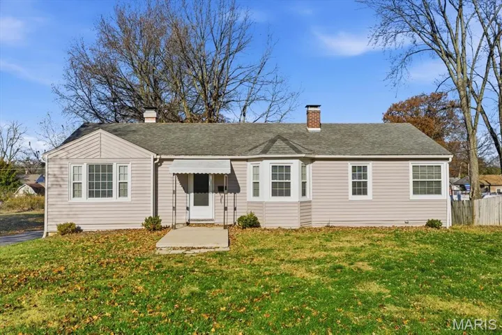 View of front of house with a chimney and roof with shingles