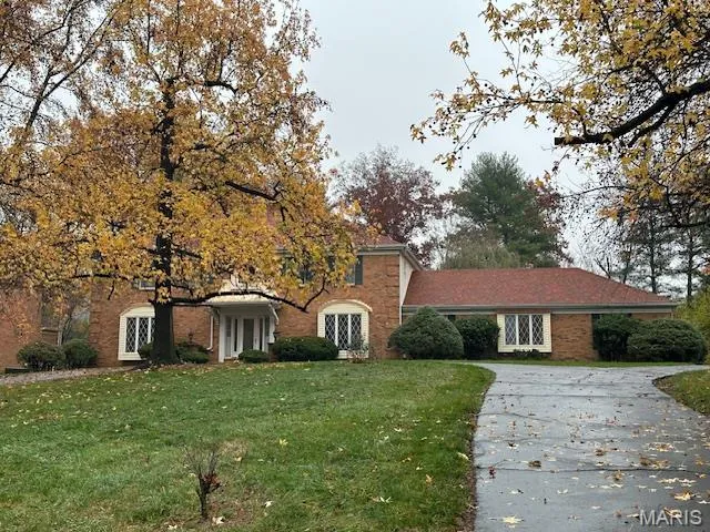 View of front facade featuring french doors, a front yard, and concrete driveway