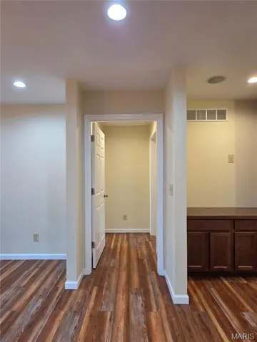 Door to Primary Bedroom with recessed lighting and laminate floors