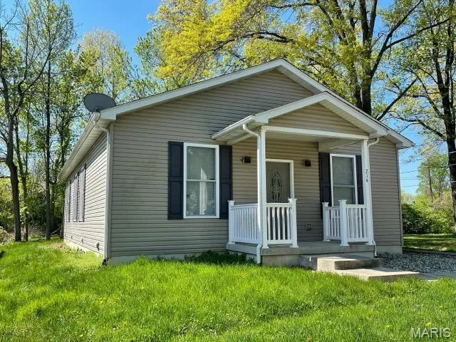 Bungalow-style home with a porch and a front yard