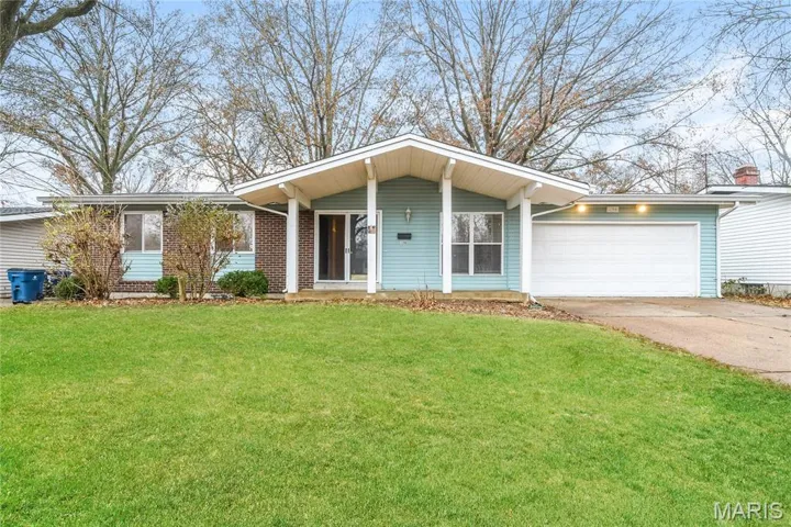 View of front of home featuring concrete driveway, a front lawn, an attached garage, a porch, and brick siding