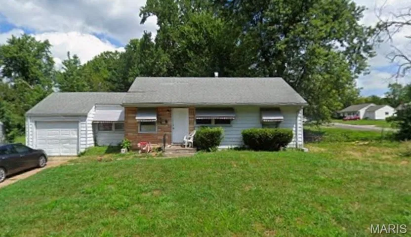 View of front of property featuring a front yard, an attached garage, covered porch, and driveway
