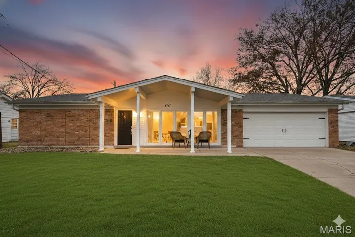 Single story home featuring brick siding, a front yard, concrete driveway, an attached garage, and roof with shingles
