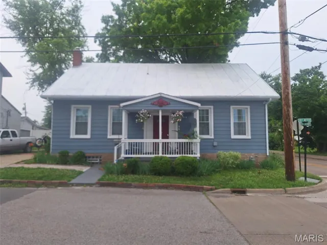 Bungalow-style house with a porch and a chimney
