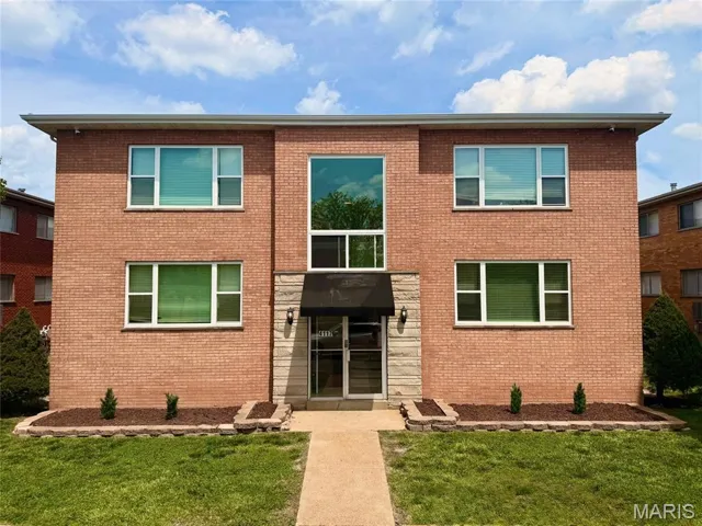 View of front of property featuring brick siding and a front yard
