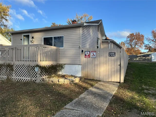 View of side of home with a chimney and a wooden deck