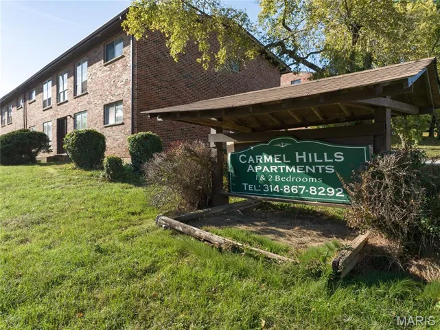 Community / neighborhood sign featuring a lawn