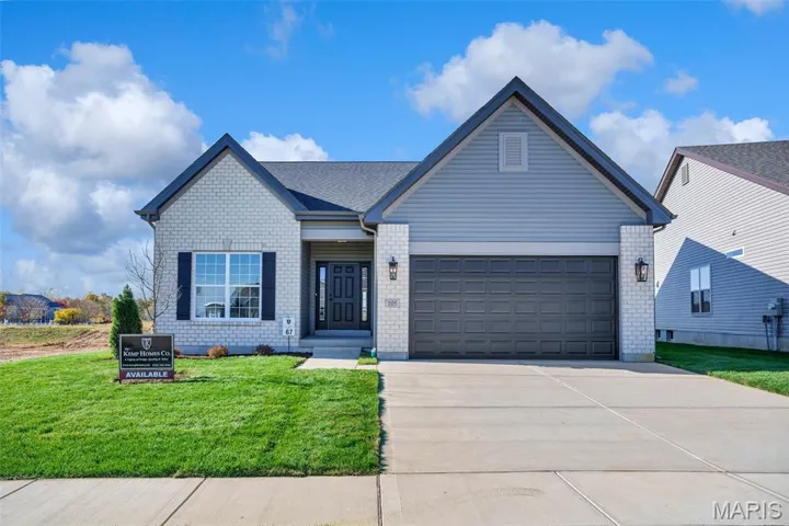 View of front of house with a front lawn, brick siding, concrete driveway, and an attached garage