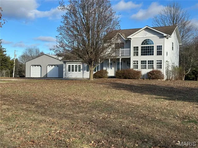View of front facade featuring a garage and a front yard