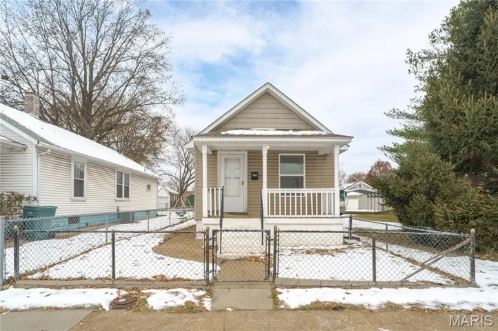 Shotgun-style home with a gate, a porch, and a fenced front yard