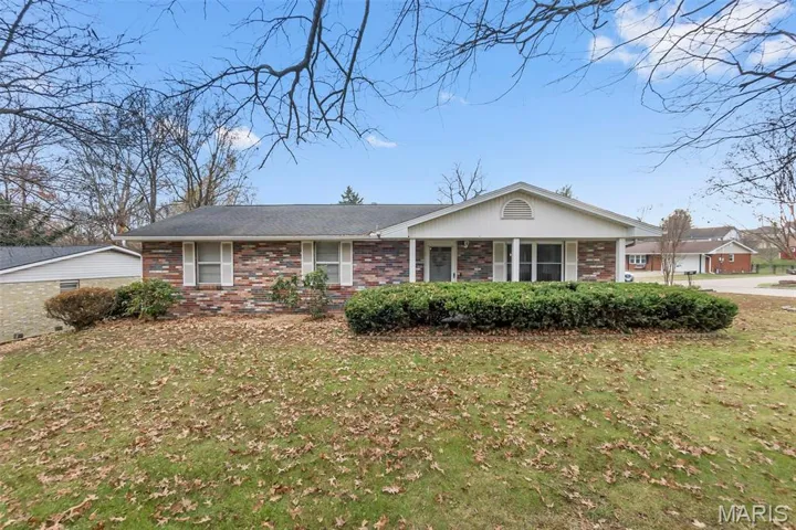 Ranch-style home featuring brick siding, a front lawn, and covered porch
