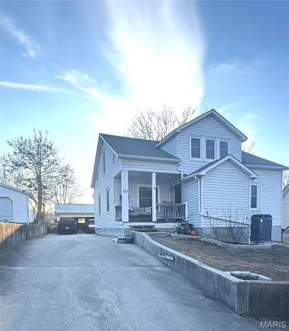 View of front of house with a porch, driveway, and roof with shingles