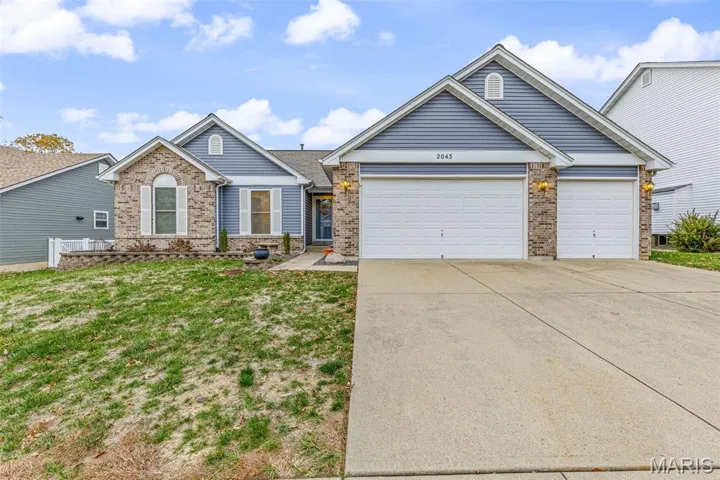 View of front of house with brick siding, concrete driveway, a garage, and a front yard