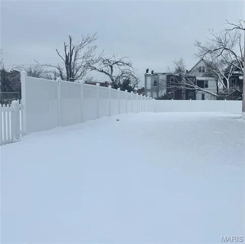 Yard layered in snow featuring a fenced backyard