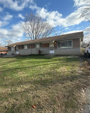 Single story home with brick siding and a front yard