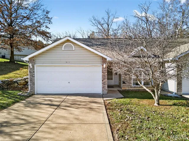 Ranch-style house with a front lawn, brick siding, driveway, roof with shingles, and an attached garage