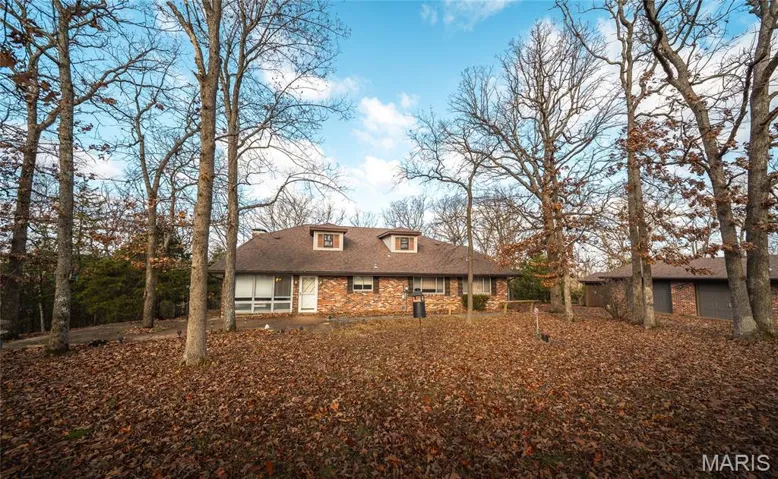 View of front of house featuring roof with shingles and brick siding
