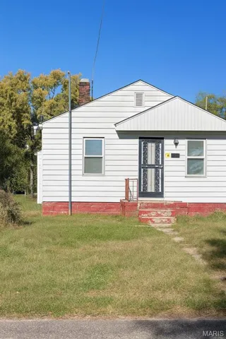 Rear view of property with a lawn and a chimney