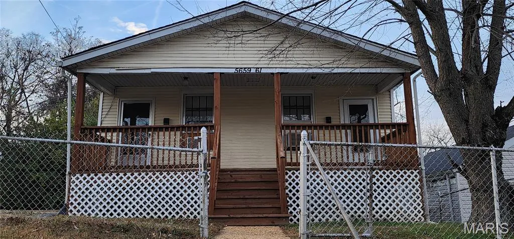 Shotgun-style home featuring covered porch and stairway
