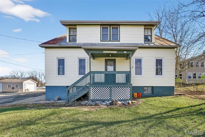 View of front of home with a front yard and a porch