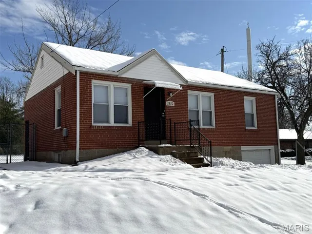 View of front of property with brick siding and a garage