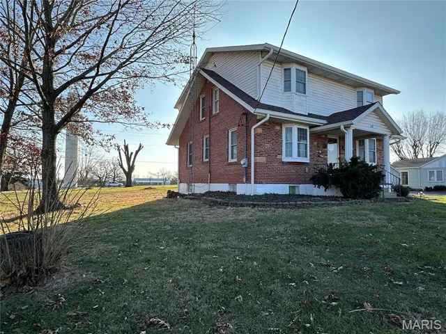 View of home's exterior with brick siding and a lawn