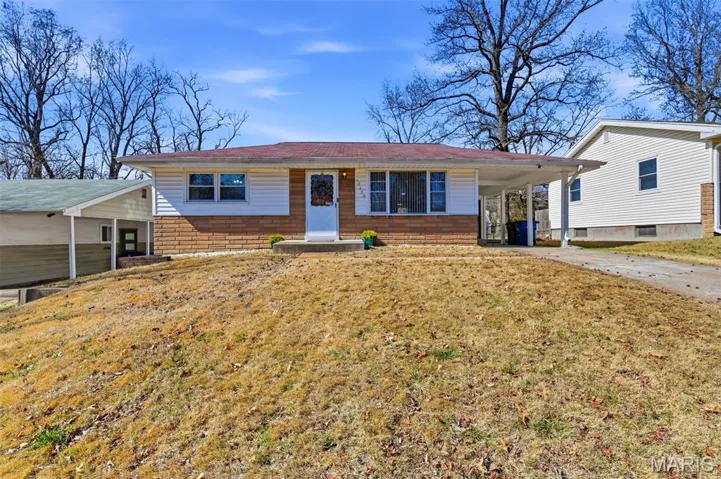 Ranch-style home with a carport, driveway, and a front lawn