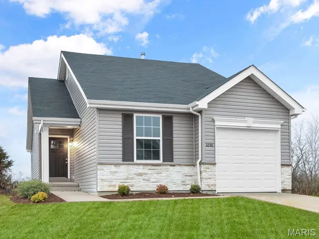 View of front facade with an attached garage, stone siding, a front yard, concrete driveway, and a shingled roof