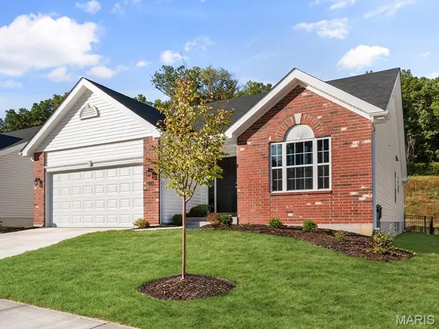 Ranch-style home with brick siding, a front lawn, driveway, and an attached garage