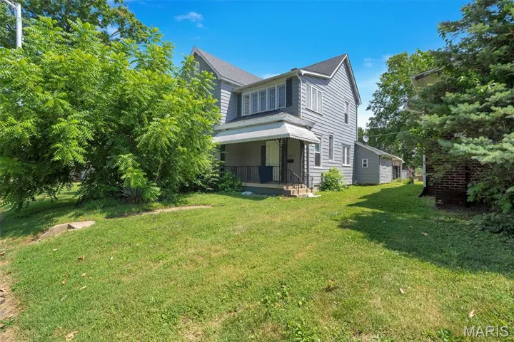 View of home's exterior featuring a yard and a porch