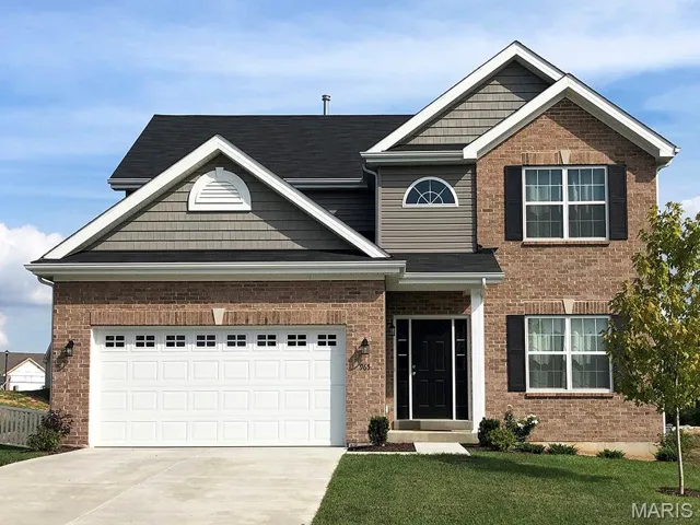 View of front of home featuring driveway, brick siding, and a front lawn