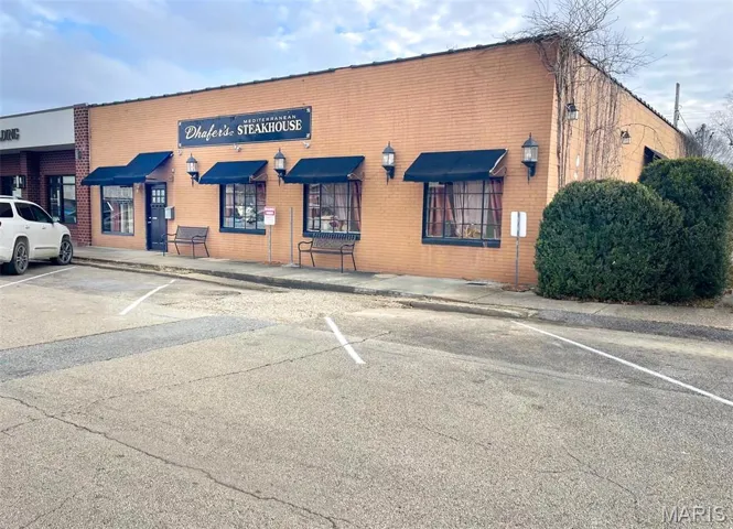 View of building exterior featuring uncovered parking