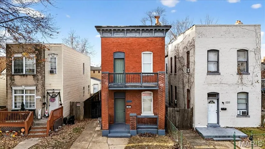 View of front facade featuring brick siding and a balcony