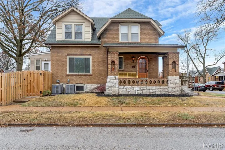 View of front of property with a porch, brick siding, and a shingled roof