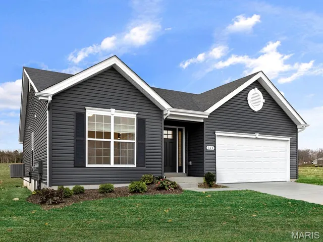 Ranch-style home with a front lawn, concrete driveway, and an attached garage